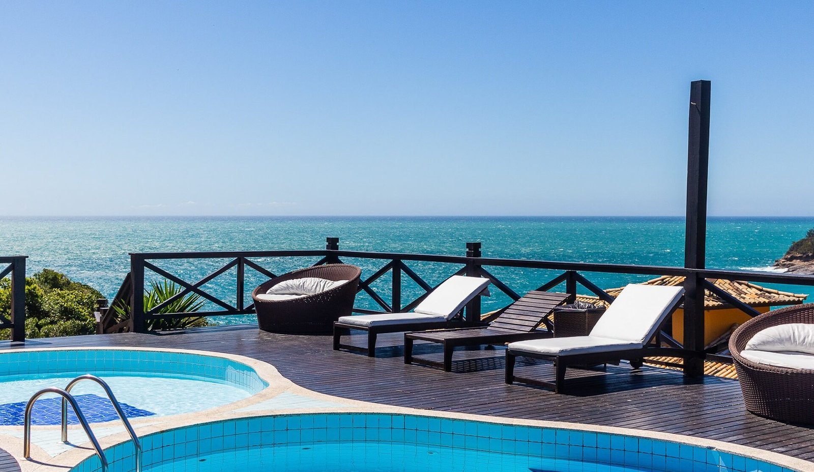 Vista aérea de resort de luxo com piscina infinita ao entardecer